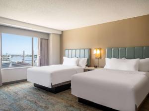 托莱多Homewood Suites By Hilton Toledo Downtown的酒店客房设有两张床和窗户。