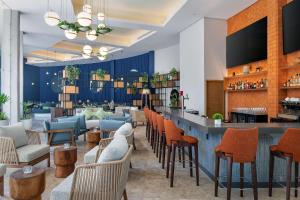 坎昆Hilton Garden Inn Cancun Airport的大堂设有酒吧和椅子