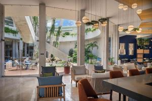 坎昆Hilton Garden Inn Cancun Airport的大楼内带桌椅的餐厅