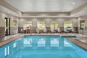 斯普林菲尔德Homewood Suites By Hilton Springfield Medical District的一个带椅子和桌子的游泳池