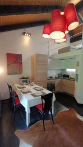 比奥焦Casa Boschetto by Quokka 360 - silent oasis in Bosco Luganese的厨房配有白色桌子和红色灯