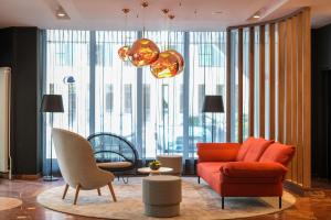 汉诺威DoubleTree by Hilton Hannover Schweizerhof的客厅配有橙色沙发和椅子