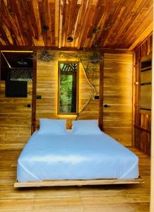 GuatemalaTamarindo Pura Selva Eco Tree House的一张位于带木制天花板的客房内的大床