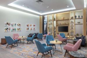 埃尔祖鲁姆Hilton Garden Inn Erzurum的一间设有桌椅和电视的等候室