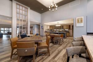 橡树溪Homewood Suites By Hilton Oak Creek Milwaukee的用餐室以及带桌椅的起居室。