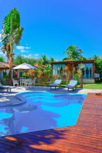 皮雷诺波利斯Villaê Pousada的度假村内带长椅的游泳池