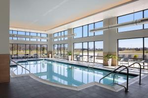 博林格林Embassy Suites By Hilton Bowling Green的一座带窗户的建筑中的游泳池