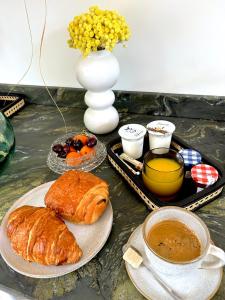 Salles-sur-MerLogis de l'Héronière的餐桌,早餐包括羊角面包和咖啡