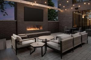 路易斯威尔Homewood Suites By Hilton Louisville Airport的一个带壁炉和砖墙电视的庭院