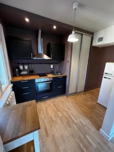 塔林Videviku Apartments的厨房配有黑色橱柜和木地板