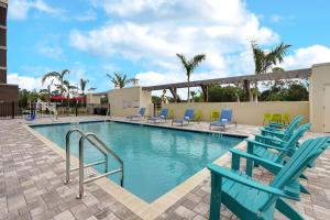 布雷登顿Home2 Suites By Hilton Lakewood Ranch的一个带蓝色椅子和滑梯的游泳池