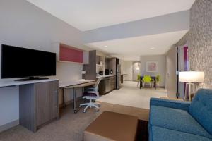 布雷登顿Home2 Suites By Hilton Lakewood Ranch的客厅配有蓝色的沙发和电视