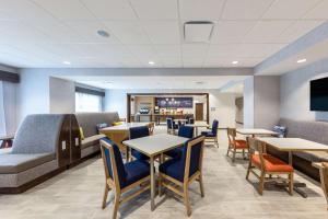 堪萨斯城Hampton Inn Kansas City Southeast, Mo的医院的等候室,配有桌椅