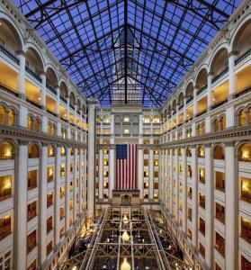 华盛顿Waldorf Astoria Washington DC的享有一座悬挂美国国旗的建筑中庭的景致