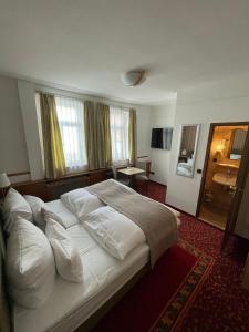 巴特乌拉赫格尼莱斯托博酒店的卧室配有带白色枕头的大床