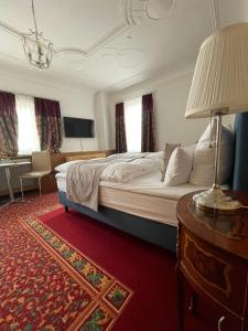 巴特乌拉赫格尼莱斯托博酒店的一间卧室配有一张床和一张带台灯的桌子