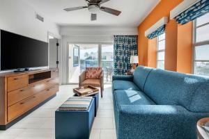辛普森湾Hilton Vacation Club Flamingo Beach Sint Maarten的客厅配有蓝色的沙发和平面电视。