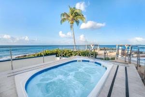 辛普森湾Hilton Vacation Club Flamingo Beach Sint Maarten的俯瞰海滩的阳台上的热水浴池