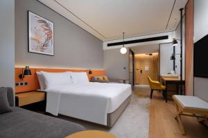杭州杭州萧山希尔顿花园酒店的酒店客房设有一张白色大床和一张书桌