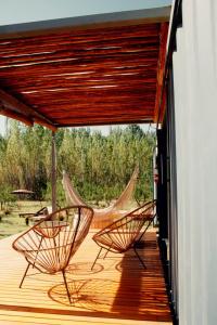 图努扬Las Guaras Valle de Uco的甲板上配有两张椅子和吊床