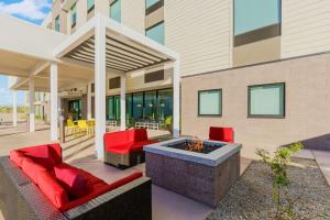 斯科茨Home2 Suites By Hilton North Scottsdale Near Mayo Clinic的一个带红色椅子和火坑的庭院