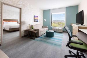 斯科茨Home2 Suites By Hilton North Scottsdale Near Mayo Clinic的一张床铺和一张书桌的酒店客房的 ⁇ 染