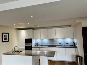 伦敦Modern 1bedflat Kensington的厨房配有白色橱柜和台面