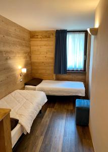 圣卡特琳娜瓦尔夫Chalet La Pineta的小型客房 - 带2张床和窗户