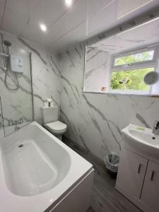 拉纳克Riverview Cottage的白色的浴室设有水槽和卫生间。