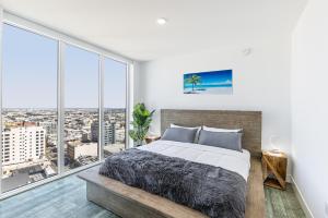 洛杉矶Top Floor High Rise 3 Bed DTLA Skyscraper Penthouse的一间卧室设有一张大床和大窗户