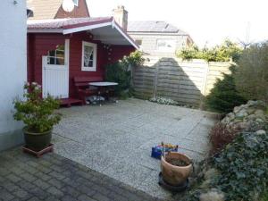 比苏姆Ferienwohnnung Westerwarft的后院,带红色房子和野餐桌