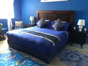 科苏梅尔Villa Segovia的蓝色卧室配有一张大床,配有蓝色的床单和枕头