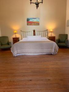 亚坎托亚卡托酒店的一间卧室配有一张带两把椅子和两盏灯的床。