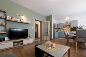 马卡尔斯卡Blue home的客厅配有平面电视和桌子。