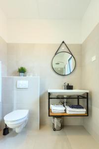 罗维尼Apartments La Scogliera Rovinj的浴室设有白色的卫生间和镜子