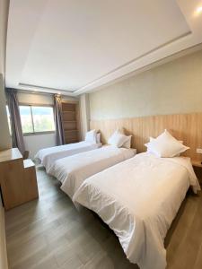 贝尼迈拉勒HOTEL PALACE AL SALAM , Beni Mellal的酒店客房,配有3张带白色床单的床