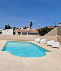 代尔特布雷Villa Barracot的一个带两把白色椅子的游泳池