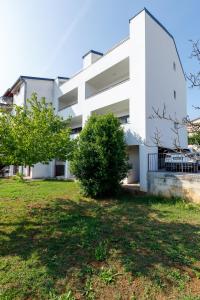罗维尼Apartments La Scogliera Rovinj的前面有树木的白色建筑