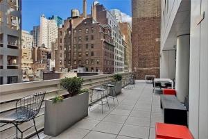 纽约Stunning 2BD Apartment on the 38th Floor in Midtown的大楼内带桌椅的阳台