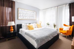 纽约Luxurious 1BD Apartment Steps from Times Square的一间卧室配有一张大床和一张橙色椅子