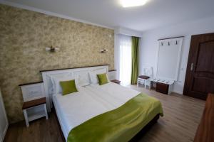 阿夫里格Evergreen Chalet的一间卧室配有一张带绿色枕头的大床