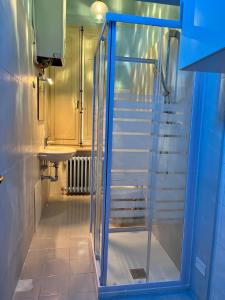 西尼加利亚Residenza del Duca的带玻璃淋浴间的浴室,设有楼梯
