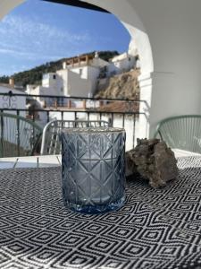Canillas de AceitunoOlive & Ivy Guesthouse的坐在阳台上桌子上的玻璃花瓶