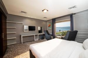 达曼阿尔科尼池金花园酒店的酒店客房配有一张床、一张书桌和一台电视。