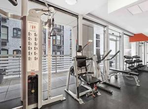 纽约Modern 2BD in Midtown with Washer and Dryer in-unit的大楼内带跑步机和椭圆机的健身房