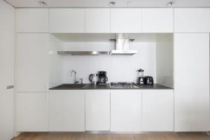 纽约Modern 2BD in Midtown with Washer and Dryer in-unit的白色的厨房配有白色橱柜和水槽