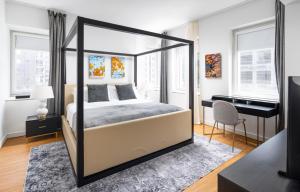 纽约Gorgeous One-Bedroom on 35th floor in Midtown的一间卧室配有一张天蓬床和一张书桌