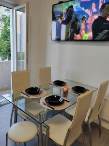 里耶卡Apartman Di Matea的一间设有玻璃桌和椅子的用餐室