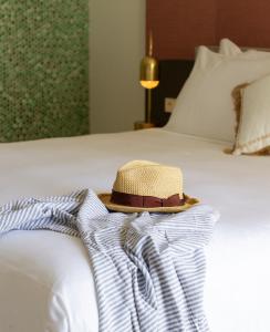圣埃乌拉利亚Boutique Apartments Marsol Ibiza的坐在床上的帽子