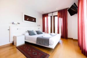 宏达瑞比亚Villa Elisa by Basquelidays的卧室配有一张带红色窗帘的大型白色床